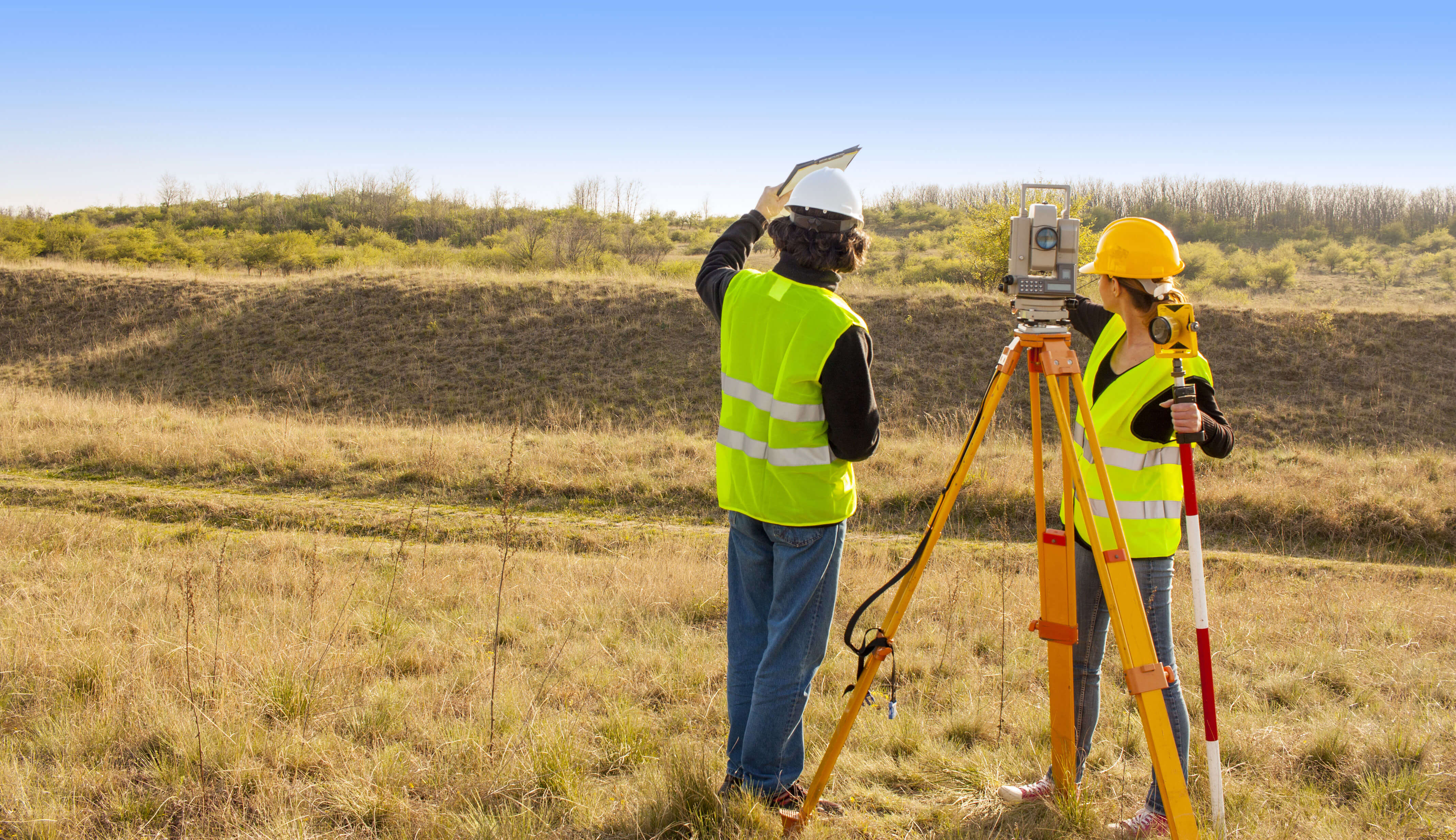 deux arpenteurs qui parlent sur un site de travail